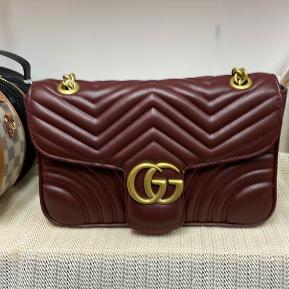 It is a dark, red woman handbag, long strap